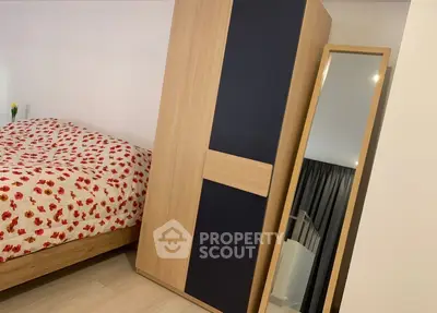 Cozy bedroom with modern wardrobe and full-length mirror, featuring floral bedding for a warm ambiance.