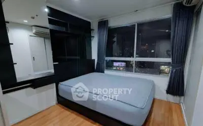 Modern bedroom with large window and city view, featuring sleek design and ample natural light.