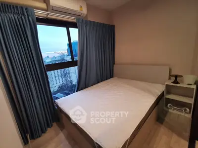 Cozy bedroom with city view, featuring a comfortable bed and modern decor, perfect for urban living.