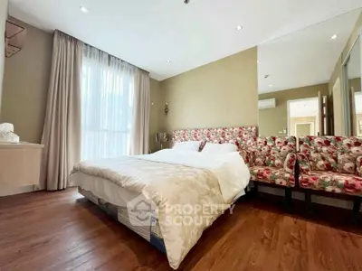 Spacious bedroom with elegant decor and large window for natural light