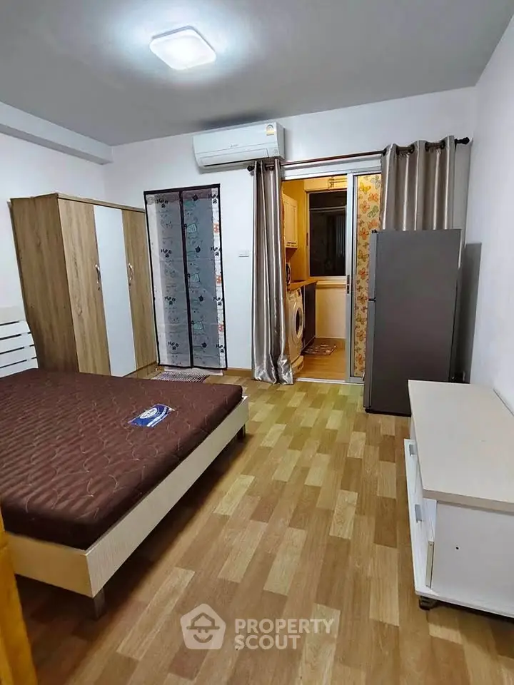 Cozy bedroom with modern furnishings and adjacent laundry area