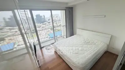 Bright bedroom with city view and balcony access in modern apartment.