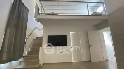Modern duplex interior with mezzanine and sleek staircase