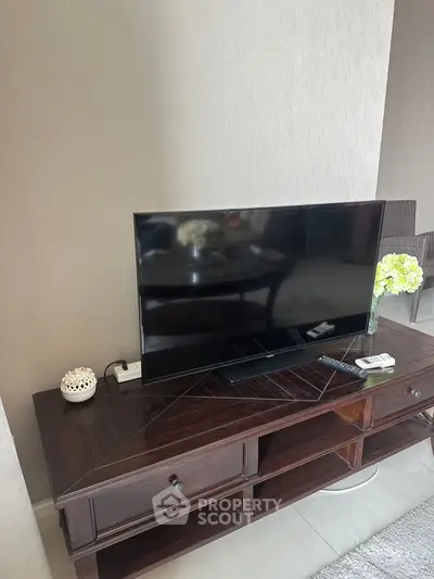 Stylish living room with modern TV setup and elegant wooden console.