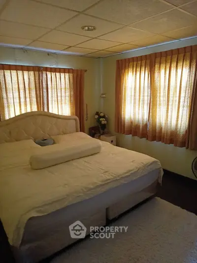 Cozy bedroom with soft lighting and elegant curtains, perfect for relaxation.