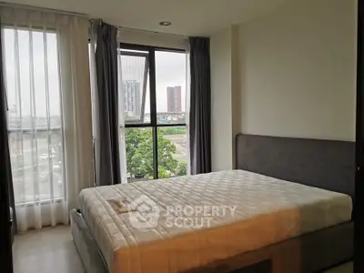 Bright bedroom with large windows offering city views in modern apartment