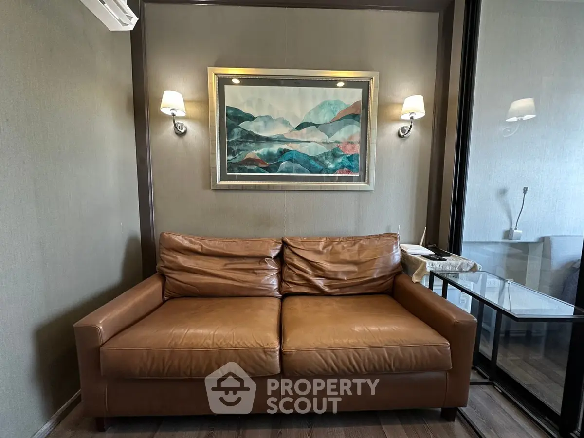 Cozy living room with leather sofa and modern art decor, perfect for relaxation.