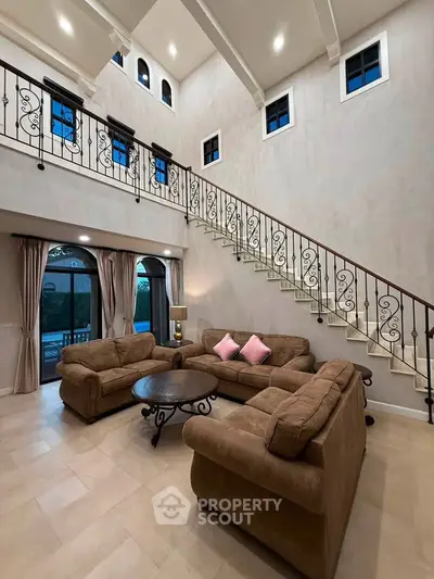 Luxurious living room with high ceilings and elegant staircase in a modern home