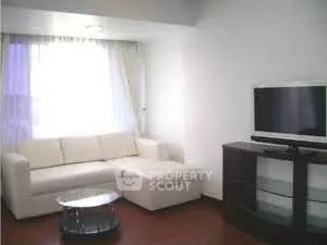 Modern living room with sleek white sofa and flat-screen TV, perfect for relaxation and entertainment.