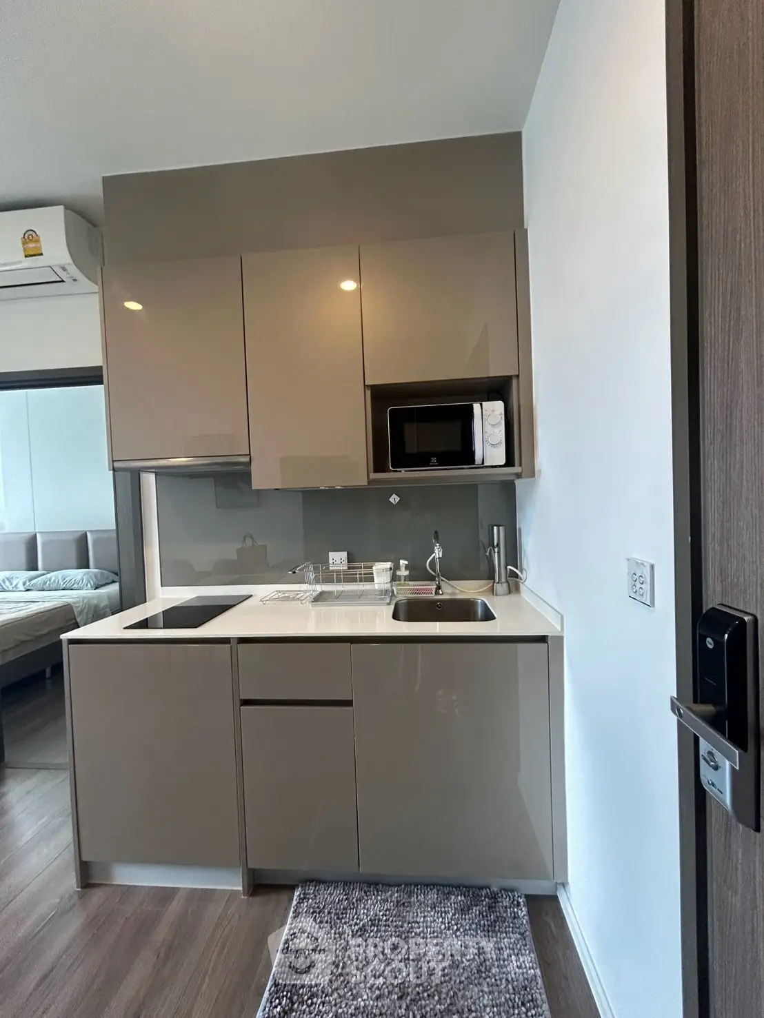 Modern compact kitchen with sleek cabinetry and built-in appliances in a stylish apartment.