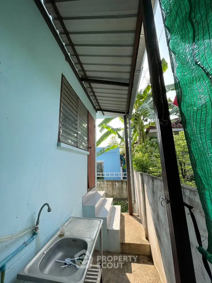 Charming exterior view with outdoor sink and steps leading to a cozy entrance.