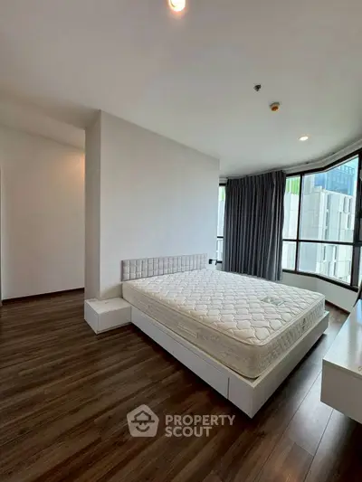 Spacious bedroom with large windows and modern design in urban apartment