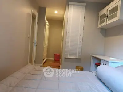 Cozy bedroom with modern decor and ample natural light, featuring a comfortable bed and stylish storage solutions.
