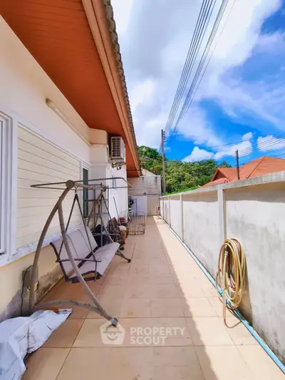 Spacious outdoor balcony with scenic view and modern swing chair, perfect for relaxation and entertainment.