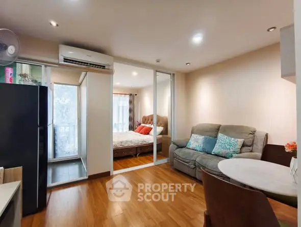 Modern apartment interior with cozy living room and bedroom, featuring wooden flooring and stylish decor.