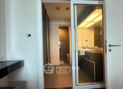 Modern bathroom with sleek design and glass sliding door in contemporary apartment.