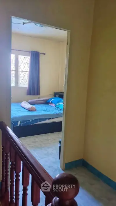 Cozy bedroom with natural light and simple decor, perfect for relaxation.