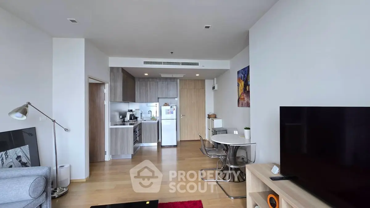 Modern open-plan living room with kitchen, featuring sleek furniture and contemporary design.