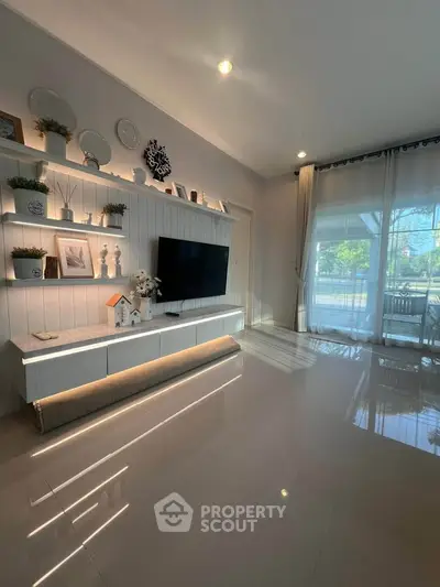 Modern living room with sleek decor and large windows offering natural light.