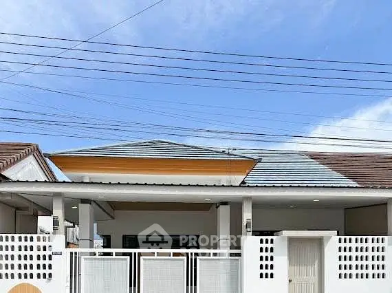 Charming single-story home with modern facade and secure gated entrance.