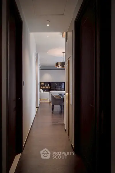 Elegant hallway leading to a modern living room with stylish decor and ambient lighting.