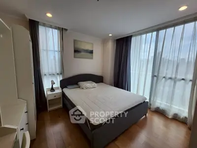 Spacious bedroom with large windows and modern furnishings