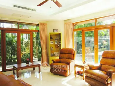 Luxurious living room with leather recliners and garden view, perfect for relaxation.
