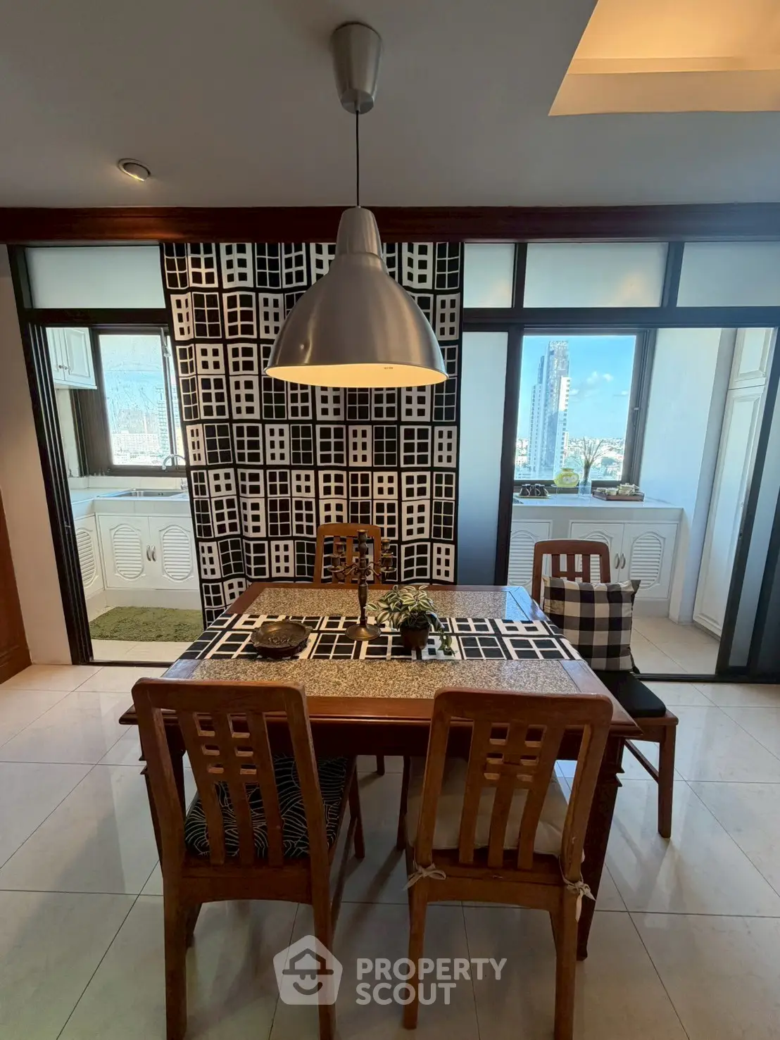 Stylish dining area with city view, featuring modern decor and wooden furniture.
