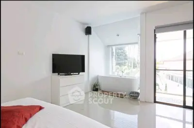 Bright bedroom with modern decor and large window view