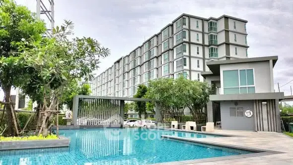 Modern apartment complex with pool and lush greenery, perfect for luxury living.