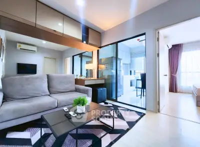 Modern living room with stylish decor and open layout leading to kitchen and bedroom.