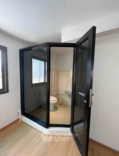 Unique bathroom with glass enclosure and modern design in a residential property.