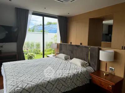 Luxurious bedroom with garden view, featuring elegant decor and ample natural light.