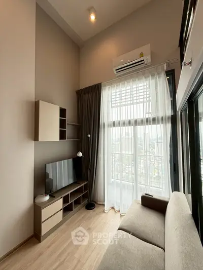 Modern living room with large windows and city view, featuring sleek furniture and neutral tones.