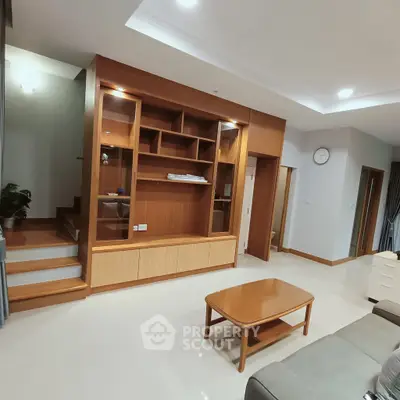 Spacious living room with modern wooden shelving and cozy seating area