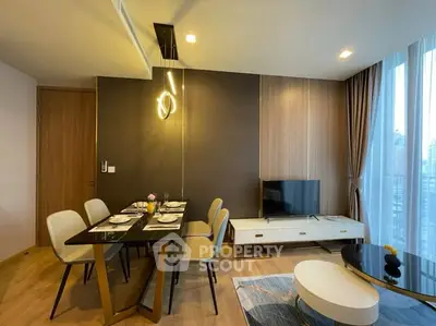 Modern living room with dining area and city view, featuring stylish furniture and elegant lighting.