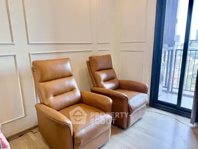 Elegant living room with leather recliners and balcony view