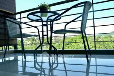 Charming balcony with modern furniture and scenic view of lush greenery.
