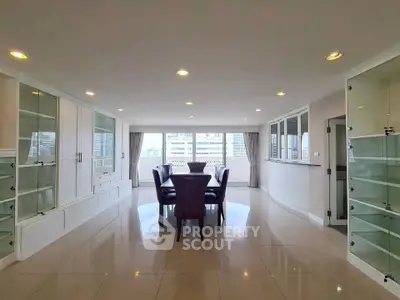 Spacious dining area with elegant glass cabinets and city view