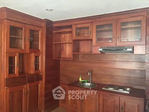 Charming wooden kitchen with closed layout and modern appliances.