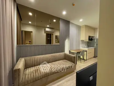 Modern living room with elegant sofa and open kitchen layout in a stylish apartment.