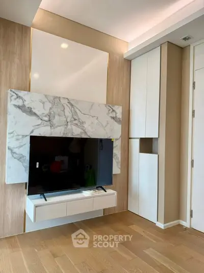 Modern living room with stylish marble TV wall and wooden flooring