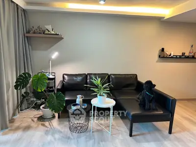 Modern living room with black leather sofa and stylish decor