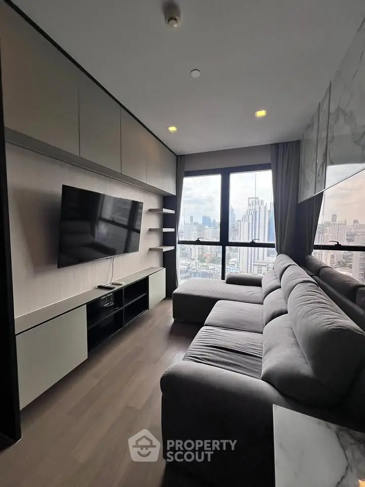Modern living room with large TV and city view from high-rise apartment