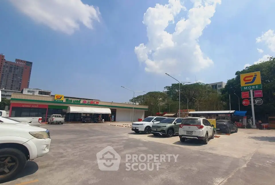 Spacious parking area in front of a convenience store with clear blue skies.