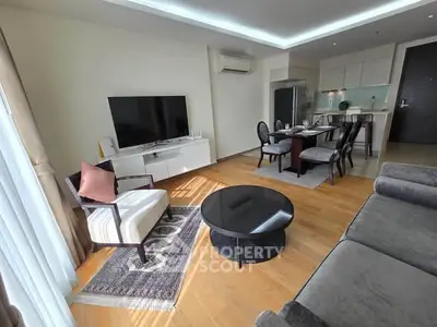 Spacious modern living room with open kitchen, featuring elegant furniture and natural light.