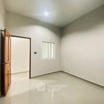 Spacious empty room with high ceiling and tiled floor, perfect for customization.
