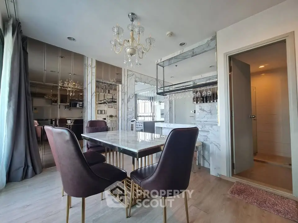 Luxurious dining area with elegant chandelier and marble accents in modern apartment.