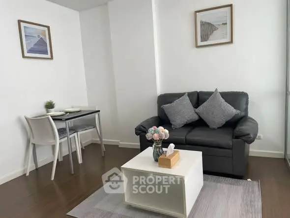 Cozy living room with modern decor, featuring a comfortable sofa and stylish dining area.