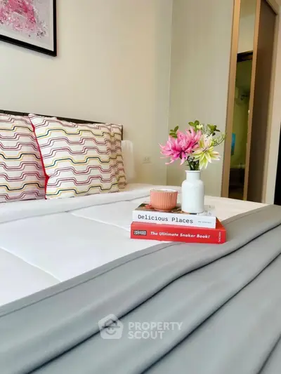 Cozy bedroom with stylish decor and fresh flowers on bedside table